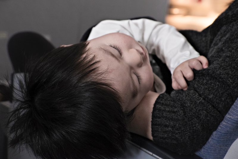 baby sleeping on father's lap - JoAnna Inks Sleep Solutions