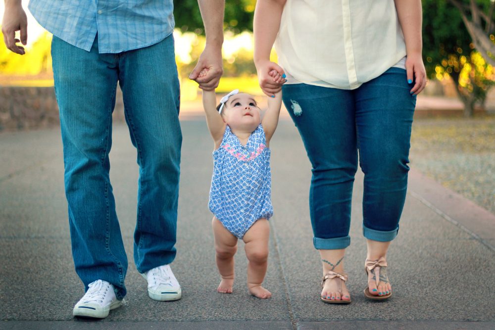 parents walking with baby girl - JoAnna Inks Sleep Solutions